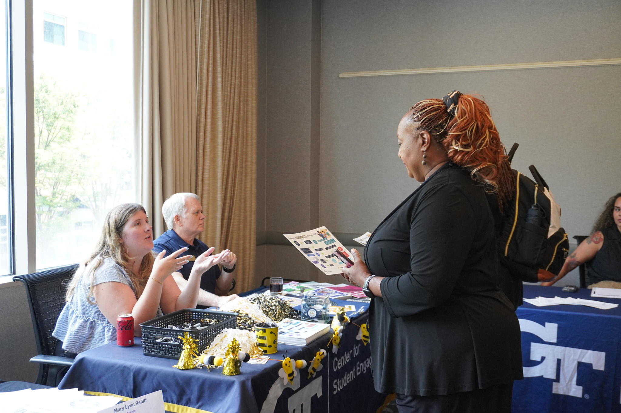 An individual speaking to representatives at the resource fair.