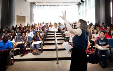 teacher standing in front of class in auditorium